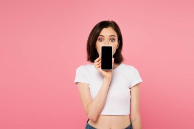 pembe izole boş ekran ile akıllı telefon tutan sürpriz kız