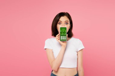 surprised girl holding smartphone with health tracking app isolated on pink clipart