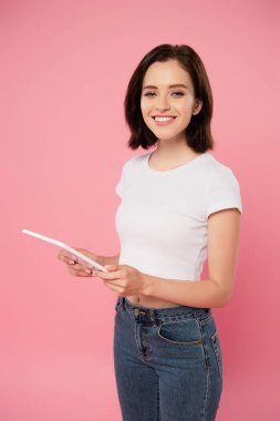 pembe izole dijital tablet kullanarak güzel gülümseyen kız