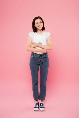 pembe izole dizüstü tutan gülümseyen güzel kız ön görünümü