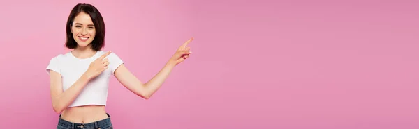 Panoramic Shot Beautiful Smiling Girl Pointing Fingers Aside Isolated Pink — Stock Photo, Image