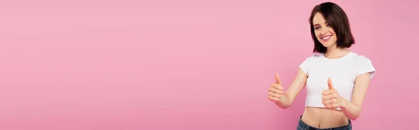 Πανοραμικό Σφηνάκι Όμορφη Χαμογελαστή Κορίτσι Δείχνοντας Αντίχειρες Επάνω Απομονωμένη Ροζ — Φωτογραφία Αρχείου