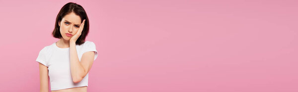 panoramic shot of beautiful sad girl with toothache isolated on pink