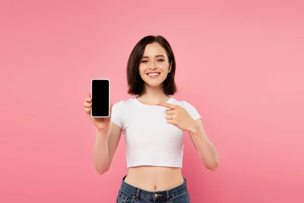 Chica Sonriente Apuntando Con Dedo Teléfono Inteligente Con Pantalla Blanco — Foto de Stock