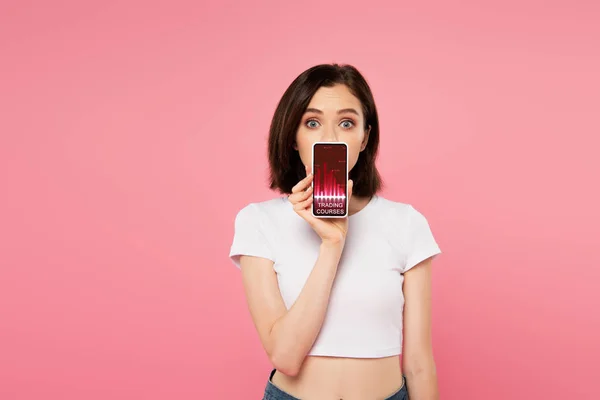 Překvapena Dívka Držící Telefon Smartphone Obchodními Kurzy Aplikace Izolovaný Růžovém — Stock fotografie