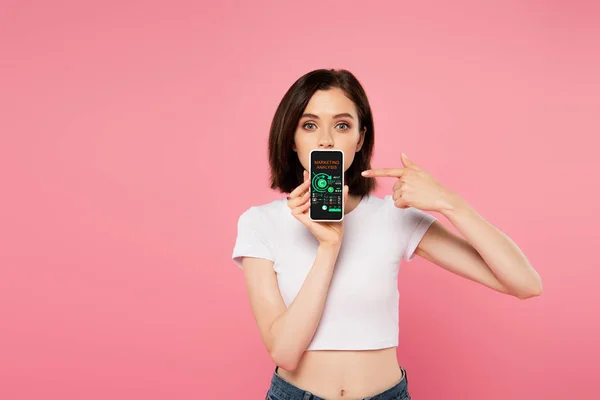Shocked Girl Pointing Finger Smartphone Marketing Analysis Isolated Pink — Stock Photo, Image