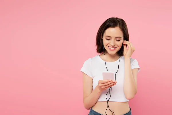 Pembe Izole Akıllı Telefon Ile Kulaklık Müzik Dinle Gülümseyen Kız — Stok fotoğraf