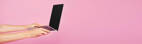 ピンクに隔離された空白の画面を持つラップトップを保持している女の子のトリミングビュー — ストック写真