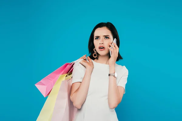 Shocked Elegant Woman Dress Shopping Bags Talking Smartphone Isolated Blue — Stock Photo, Image