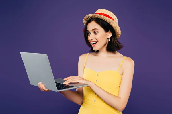 震惊微笑的女孩在草帽拿着笔记本电脑隔离在紫色 — 图库照片