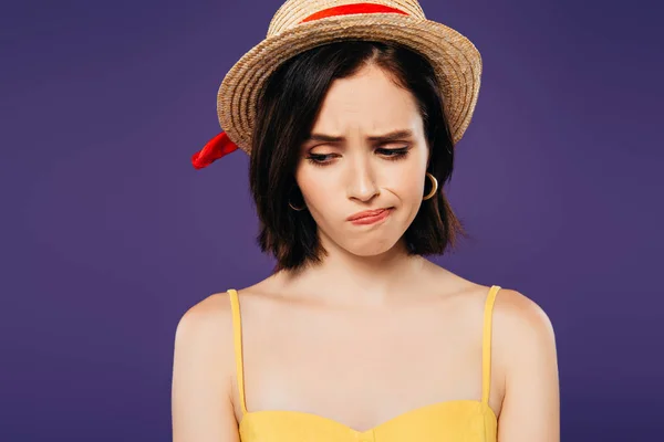 悲伤的女孩在草帽看下来孤立在紫色 — 图库照片