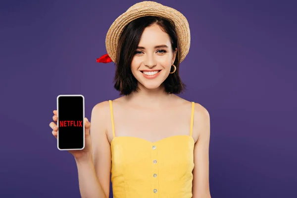 キエフ ウクライナ 7月3 2019 紫色に隔離されたNetflixアプリでスマートフォンを保持わら帽子で笑顔の女の子 — ストック写真