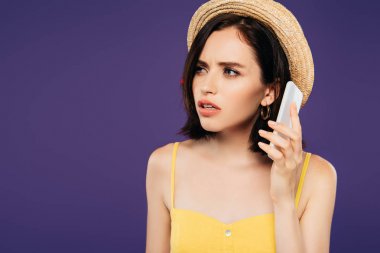 hasır şapkalı endişeli güzel kız mor izole akıllı telefon konuşuyor 
