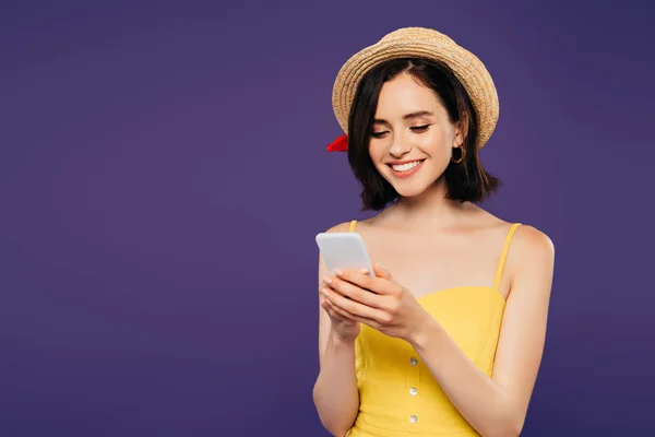 Chica Sonriente Sombrero Paja Usando Teléfono Inteligente Aislado Púrpura —  Fotos de Stock