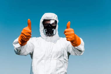 koruyucu maske ve üniforma ayakta ve başparmak gösteren yok edici 