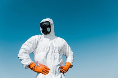 koruyucu maske ve kalça elleri ile ayakta üniforma yok edici 