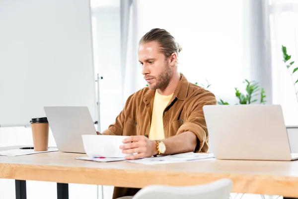 Hombre Guapo Haciendo Papeleo Mirando Computadora Portátil — Foto de Stock