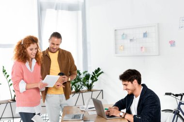 ofiste dizüstü bilgisayar kullanan dijital tablet ve adam bakarak arkadaşlar 