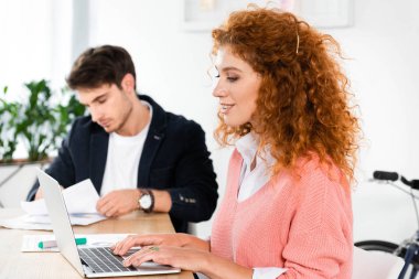 dizüstü bilgisayar kullanarak ve ofiste evrak yapıyor arkadaşlar seçici odak 