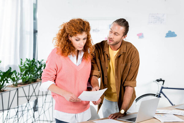 two friends talking and doing paperwork in office 