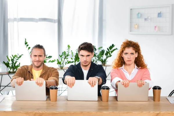 Three Sad Friends Sitting Table Holding Laptops Office — Stock Photo, Image