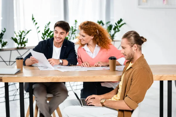 Three Smiling Friends Doing Paperwork Using Laptop Office — Stock Photo, Image