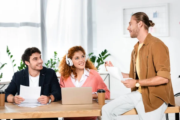 Tres Amigos Sonrientes Sosteniendo Papeles Hablando Oficina — Foto de Stock