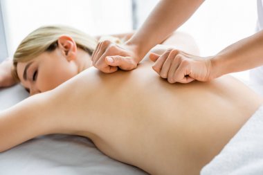 spa kadına sırt masajı yapan masör kırpılmış görünümü 