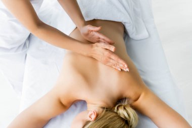 spa kadına sırt masajı yapan masör kırpılmış görünümü 