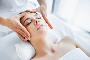 çekici kadına yüz masajı yapan masör kırpılmış görünümü 