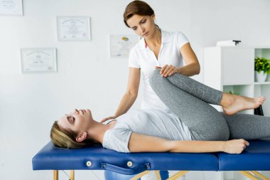 gri t-shirt çekici hastanın chiropractor dokunmadan bacak 