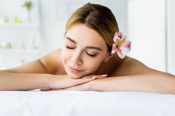 Attraktive Frau Mit Blume Liegt Auf Massagematte Wellnessbereich — Stockfoto