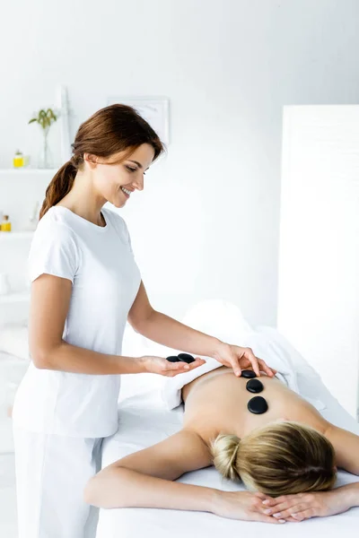 Massagista Atraente Sorridente Fazendo Massagem Pedra Quente Para Mulher Spa — Fotografia de Stock