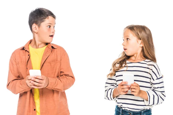 Two Shocked Kids Using Smartphones Looking Each Other Isolated White — Stock Photo, Image