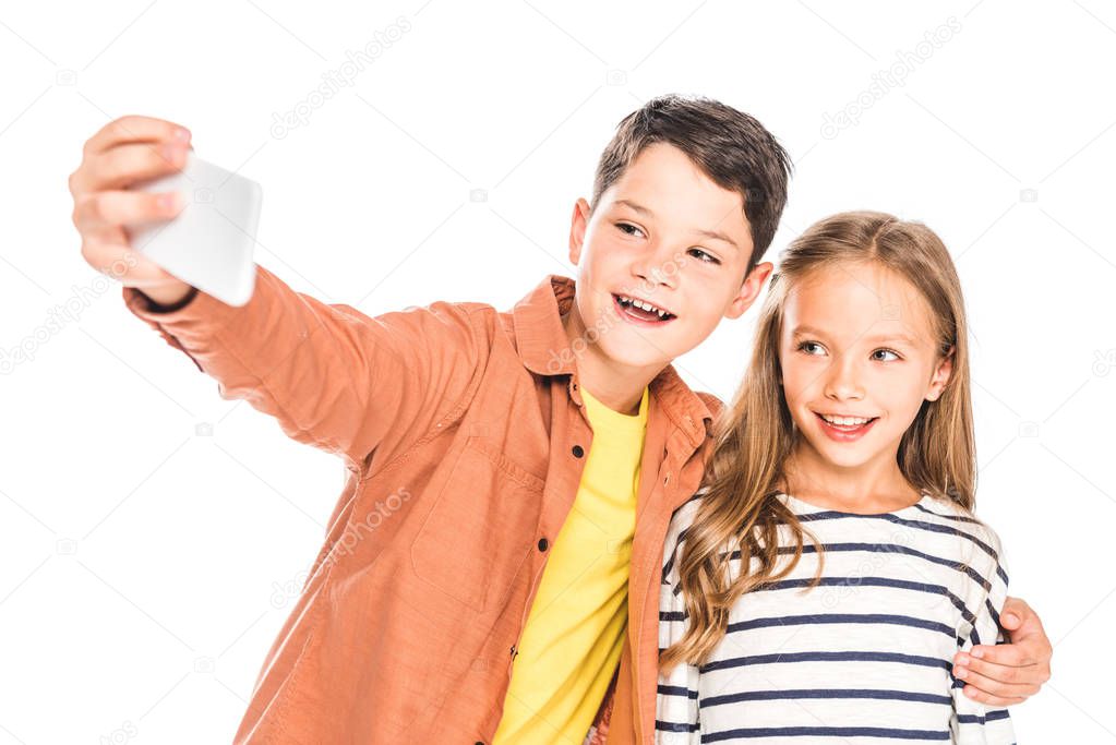 two smiling kids taking selfie isolated on white