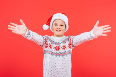 kırmızı izole kazak ve santa şapka gülümseyen çocuk ön görünümü