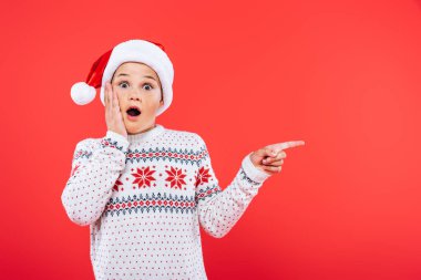 kırmızı izole parmak ile işaret santa şapka lı sürpriz çocuk ön görünümü