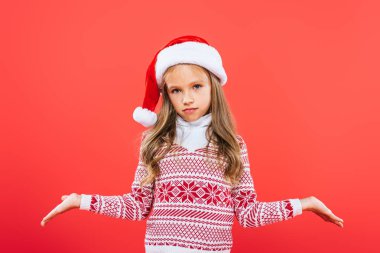 kırmızı izole omuz silkme jestgösteren santa şapkalı çocuğun ön görünümü