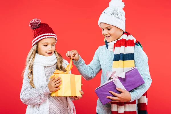 Two Smiling Kids Winter Outfits Holding Presents Isolated Red — Stock Photo, Image