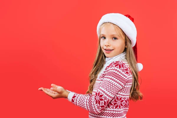 Smiling Kid Sweater Santa Hat Outstretched Hands Isolated Red — Stock Photo, Image