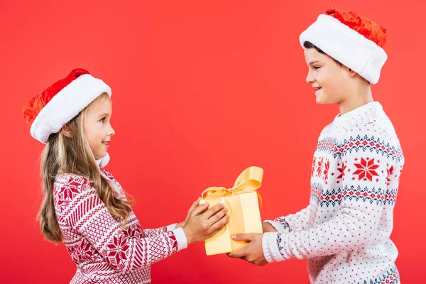 Two Smiling Kids Santa Hats Present Looking Each Other Isolated — Stock Photo, Image