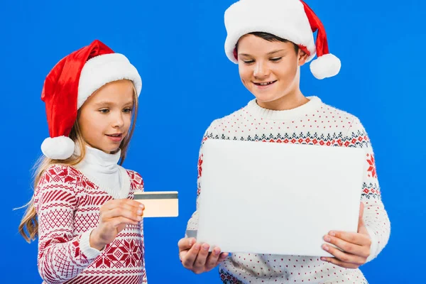 Two Smiling Kids Santa Hats Laptop Credit Card Isolated Blue — Stock Photo, Image