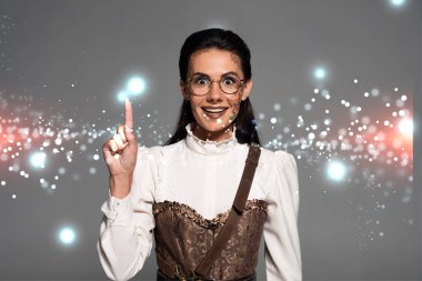 Heyecanlı çekici steampunk kadın parlak resimli gri üzerinde izole fikir işareti gösteriyor.