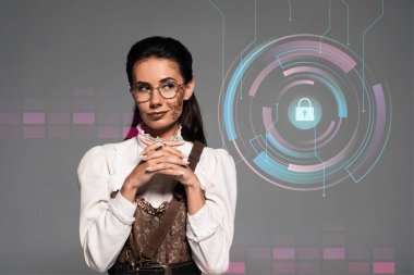 pensive steampunk kadın gri izole sıkıştırılmış elleri ile uzağa bakıyor