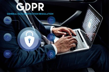 Afrika kökenli Amerikalı iş adamının arabasında GDPR illüstrasyonlu dizüstü bilgisayar kullanırken kısmi görüntüsü