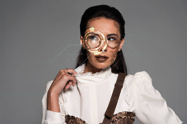 pensive steampunk woman with digital illustration on face looking away isolated on grey