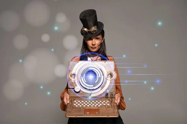 steampunk woman in top hat with goggles showing vintage laptop with glowing digital illustration isolated on grey