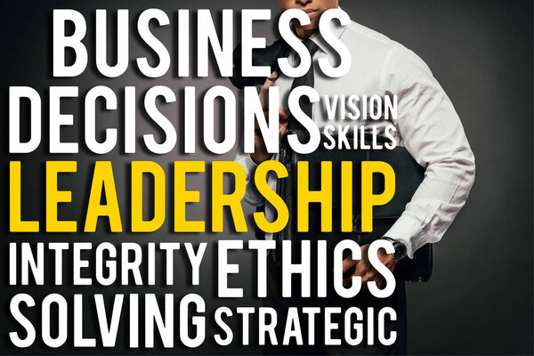 обрезанный вид африканского американского бизнесмена с блейзером и кожаным портфелем на темном фоне с иллюстрацией деловых слов
