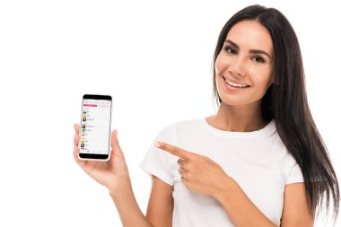 Kyiv, Ukrayna - 3 Eylül 2019: ekranda izole edilmiş elma müziği uygulaması ile akıllı telefonu işaret eden mutlu kadın 