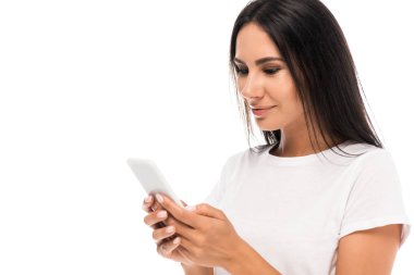 Beyaz tişörtlü mutlu kadın beyaz üzerinde izole akıllı telefon kullanıyor. 